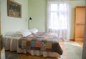 a bedroom with a bed with a quilt on it at Lakeside Guesthouse, Lillstugan in Ramvik