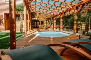 a patio with a hot tub on a wooden deck at Morze Domków Wellness & Spa in Dziwnówek