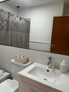 a bathroom with a sink and a toilet and a mirror at MC Departamentos Villa Allende in Villa Allende