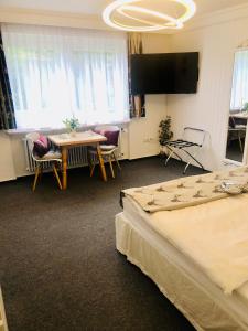 a room with two beds and a table and a tv at Haus Anna-Marie in Feldberg