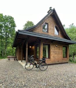 a bike parked in front of a log cabin at Villejka, domki i domy wakacyjne in Wetlina