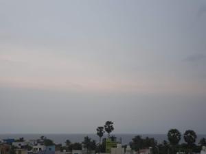 a city skyline with palm trees in the distance at Auro Maison in Puducherry