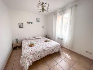 - une chambre blanche avec un lit et une fenêtre dans l'établissement La Provençale, à Redessan