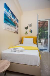 a bedroom with a bed with a yellow headboard at Sofia's Delightful Apartment in Argostoli