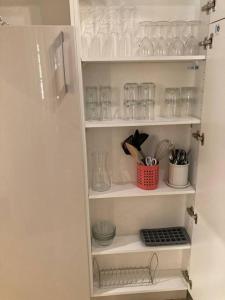 a cupboard filled with glasses and utensils at Studio cosy Cours Mirabeau au cœur d'Aix-en-Provence in Aix-en-Provence