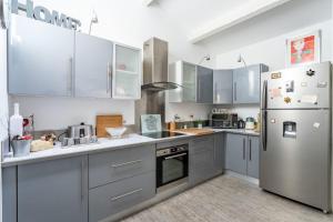 a kitchen with stainless steel appliances and gray cabinets at Bright pearl with garden near the sea in Hyères