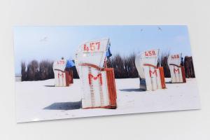 una fila de sillas de hielo en la nieve en Ferienwohnung Bensersiel Ahoi en Bensersiel