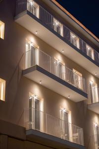 an apartment building with balconies at night at Contessa Bianca Luxury Suites in Corfu Town