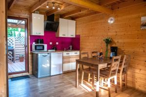 a kitchen with a table and chairs in a cabin at Morze Domków Wellness & Spa in Dziwnówek