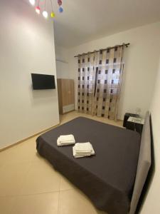 a room with a bed with two towels on it at Sabea Guest House in Melissano