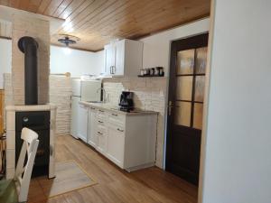 cocina con armarios blancos y estufa negra en Triglav Cottage, en Bohinj