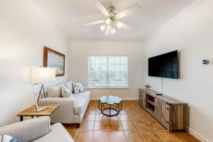 a living room with a couch and a flat screen tv at Dauphin Island Beach Club 210B in Dauphin Island