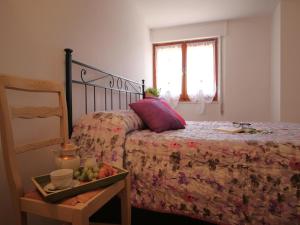 Un dormitorio con una cama con una bandeja de fruta. en La casa di Beppin, en Sassello