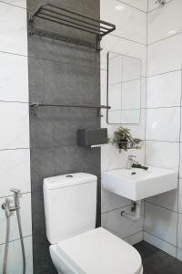 ein weißes Bad mit einem WC und einem Waschbecken in der Unterkunft 38 villa homestay in Muar