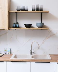 a kitchen with a sink and wooden shelves at Arbona Apartment Ι in Vóroi