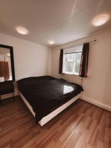 セイジスフィヨルズルにあるCozy apartment in Seydisfjordurのベッドルーム(黒いベッド1台、窓付)