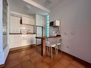 cocina con mesa y sillas en una habitación en Apartamentos La Cebada, en Morro del Jable