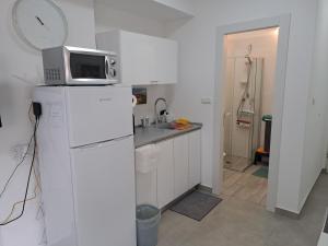 a kitchen with a microwave on top of a refrigerator at סטודיו במרכז מודיעין in Modi'in-Maccabim-Re'ut