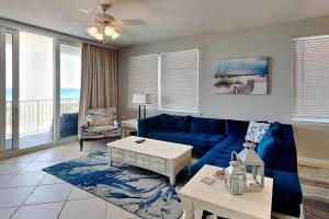 a living room with a blue couch and a table at Summerwinds #204 in Navarre