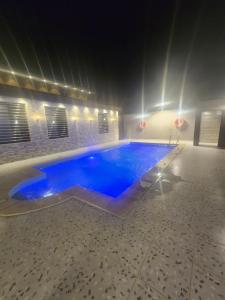- une grande piscine d'eau bleue dans une chambre dans l'établissement شاليه ومنتجع النخيل الريفي, à Taif
