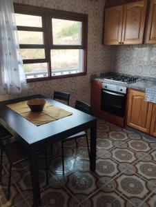 uma cozinha com uma mesa, um fogão e uma janela em Vivienda vacacional em Mocanal