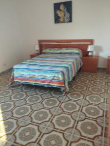Un dormitorio con una cama con una manta de colores. en Vivienda vacacional, en Mocanal