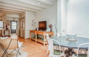 a dining room with a table and a television at 2 Bedroom Nice Home In Imon in Imón