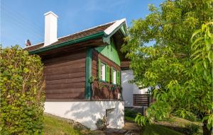 ein kleines Haus mit einer grünen und weißen Fassade in der Unterkunft Amazing Home In Deutsch Schtzen With 1 Bedrooms in Deutschschützen