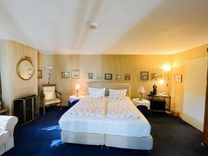 a bedroom with a large white bed and two chairs at Landhaus Ettenbühl Bed and Breakfast in Bad Bellingen