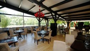a restaurant with tables and chairs and windows at Hotel du Lac & Restaurant Foix in Foix +50 photos