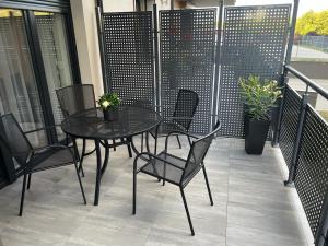 una mesa negra y sillas en el balcón en Apartament Korczak Park, en Kalisz