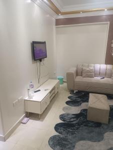 sala de estar con sofá y TV en la pared en شقه مفروشه علي جسر السويس, en El Cairo