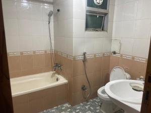 a bathroom with a tub and a toilet and a sink at 2 Bedroom Apartment F11 Islamabad - Askin in Islamabad