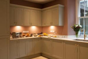 a kitchen with white cabinets and a sink at Moss Grove Organic in Grasmere