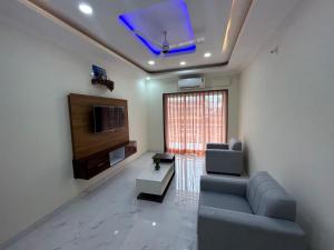 a living room with a couch and a tv at HOLIDAY LUXURY APARTMENT in Arpora