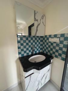 a bathroom with a sink and a mirror at HOLIDAY LUXURY APARTMENT in Arpora