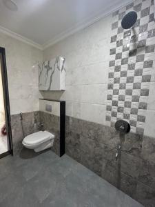 a bathroom with a toilet and a sink in it at HOLIDAY LUXURY APARTMENT in Arpora