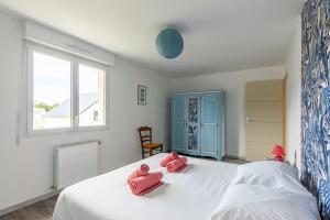 - une chambre avec 2 serviettes roses sur un lit dans l'établissement Les Fuchsias - Maison proche de la mer, à Asnelles