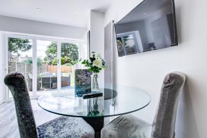 a dining room with a glass table and two chairs at Pass the Keys Beautiful large modern house in Southend in Southend-on-Sea