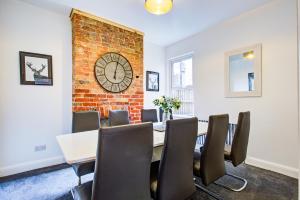 a dining room with a brick wall and a table and chairs at Pass the Keys Beautiful large modern house in Southend in Southend-on-Sea