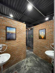 a brick bathroom with two sinks and a brick wall at IKIGAI Dorm Hostel - Danang Beach in Da Nang