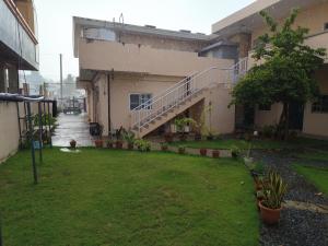 an empty courtyard of a building with a yard at Oh My House in Garapan