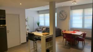 cocina y sala de estar con mesa y reloj en Ruime studio in Deurne, en Amberes