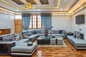 een woonkamer met banken en een televisie bij Dirleh Hotel in Skardu