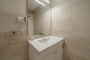 een badkamer met een witte wastafel en een spiegel bij Bright & Stylish Apartment Near Parque Da Cidade by Vacationy in Porto