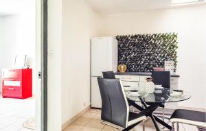 a kitchen with a table and chairs and a refrigerator at Stunning Apartment In Marignane With Wifi And 1 Bedrooms in Marignane