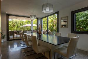 a dining room with a black table and chairs at Villa Diagonal in Can Picafort
