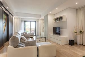 a living room with a couch and a tv at Villa Diagonal in Can Picafort