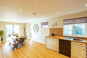 a kitchen and dining room with a table and a sink at Sparrowhawk Cottage with Hot Tub in Newton Stewart