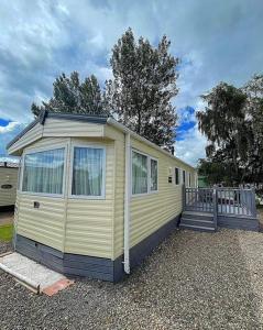 a yellow tiny house sitting on top of gravel at The Rannoch Len 1 in Forfar